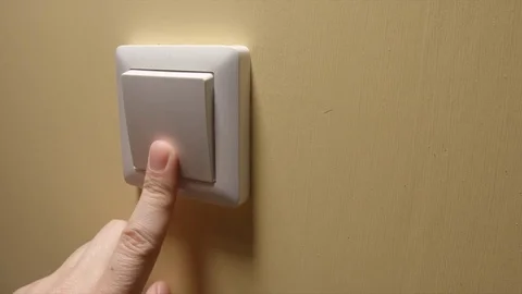 Human hand turn off a power button on a yellow wall - side view Stock Footage 75564801