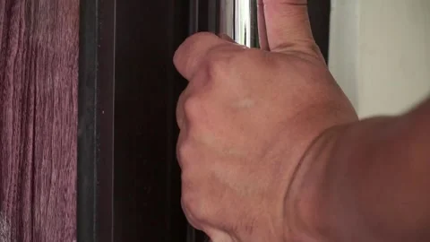 Human hand turning and pulling a shiny door handle to open a wooden door. Stock Footage 322567725