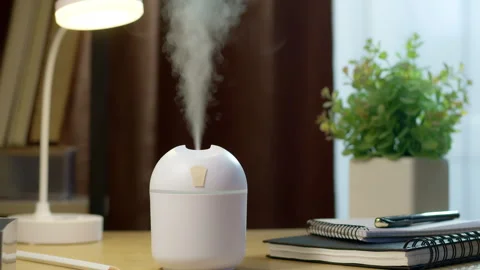 Human hand turns on white portable air humidifier on office desktop interior. Vídeo Stock 329167301