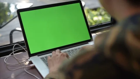 Human hand typing computer laptop with green screen in the coffee shop. Stock Footage 85043307