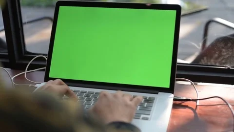 Human hand typing computer laptop with green screen in the coffee shop. Stock Footage 85043436