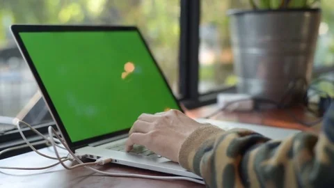Human hand typing computer laptop with green screen in the coffee shop. 库存影片 85043565