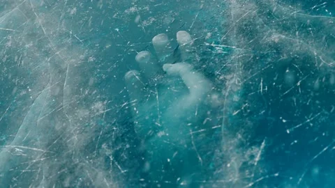 A human hand under the ice. The dead body is trapped underwater below the ice. Stock Footage 139771416