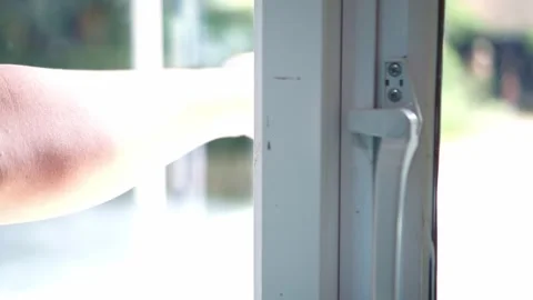 Human hand unlocking and opening a white window frame indoors. Stock Footage 340322431