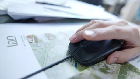Human hand uses black wired computer mouse on top map Stock Footage 339278264