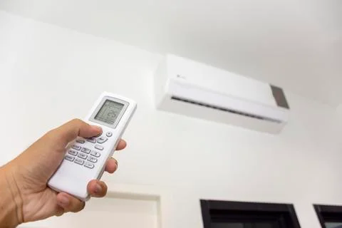 Human hand is using air conditioner remote. Stock Photos