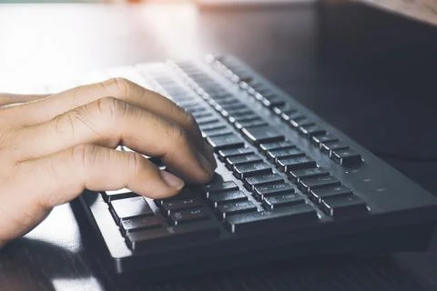 Human hand using computer keyboard on desk Stock Photos