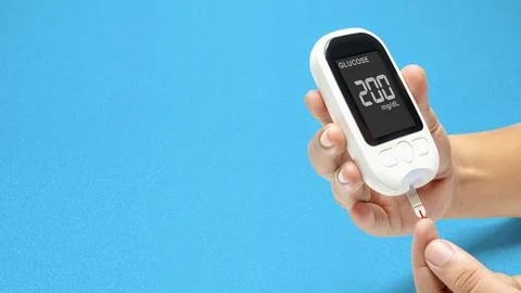 Human hand using a glucometer for checking the blood sugar level with a blu.. 写真素材
