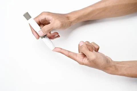 Human hand using a lancet for checking blood sugar level isolated over a wh.. 写真素材