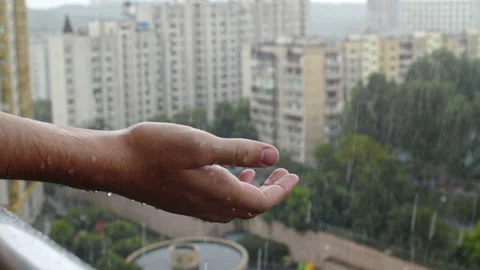 Human hand of an young man under rain.  Raindrops slowly falls onto human pal Stock Footage 194402225