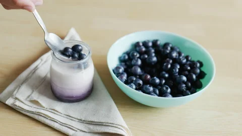 Human hands adding cranberries on a yogurt, healthy eating concept Stock Footage 211061443