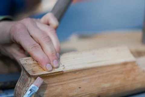 Human hands applying bone glue with brush on piece of old wooden furniture Stock Photos