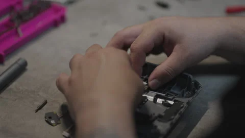 Human hands assembling electronic joystick components on a workbench for a Stock Footage 301586466