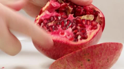 Human hands break into pieces a ripe, juicy, appetizing pomegranate fruit. Stock Footage 259954668