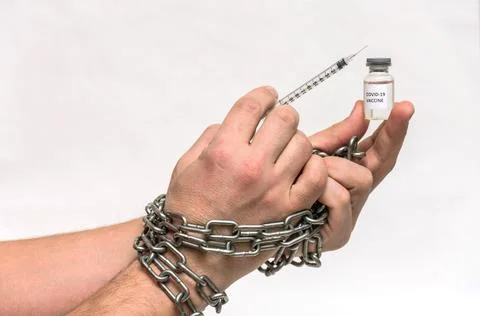 Human hands chained in chains are taking an injection into a syringe from an amp Stock Photos