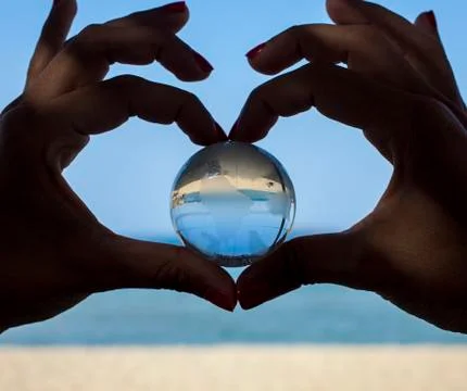 Human hands with crystal globe Stock Photos