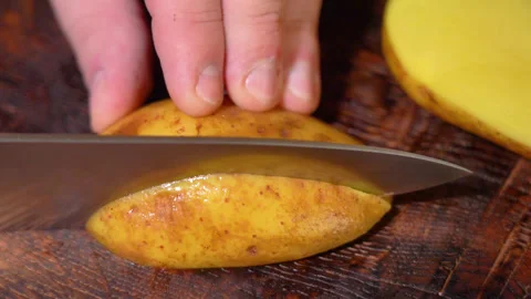 Human hands cut boiled potatoes into slices. Stock Footage 250441239