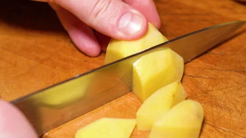 Human hands cut raw potatoes into slices. Stock Footage 248069687