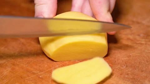 Human hands cut raw potatoes into slices. Stock Footage 248530567