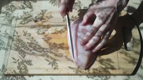Human hands cutting on cubic, raw tender chicken breast or fillet with sharp Stock-Footage 133810663