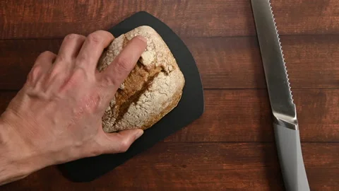 Human hands cutting a homemade bread on a slate cutting board.  Stock Footage 196593505