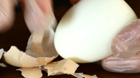 Human hands with fingers peel eggshells from boiled eggs. Vídeo Stock 131725810