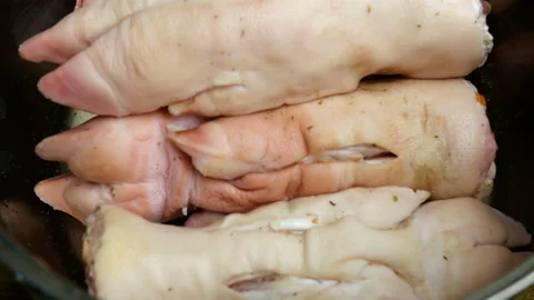 Human hands in gloves put raw pork legs in metal cooking pan. Stock Footage 129510288