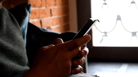 Human hands hold and tap screen of smartphone by fingers Stock Photos