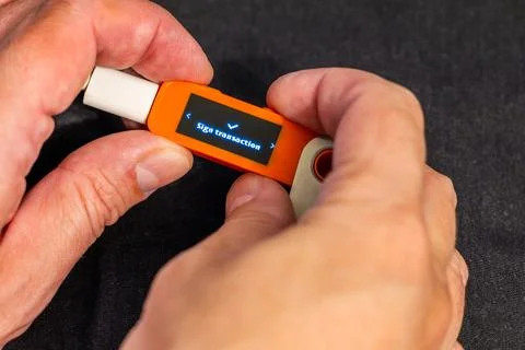 Human hands holding hardware wallet while signing transaction Stock Photos