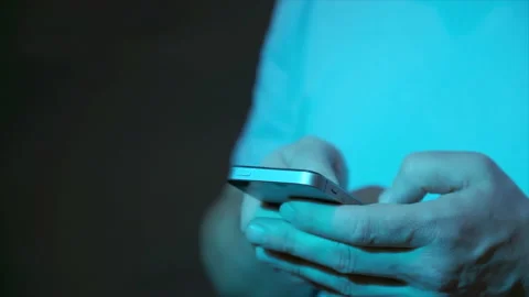 Human hands holding smartphone in blue neon light, typing and using apps Stock Footage 145930177
