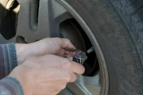 Human hands insert the hose of the car pump Stock Photos