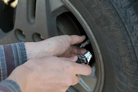 Human hands insert the hose of the car pump Stock Photos