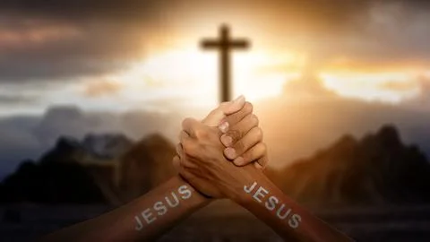 Human hands with Jesus text joined together with a Christian cross on the h.. Photos