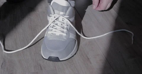 Human hands lace up gray sneakers Stock-Footage 128466341