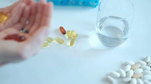 On human hands lying red and yellow transparent capsules Video stock 73226672