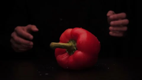 Human hands pick up colored red pepper from the table on a dark background Stock Footage 144370476