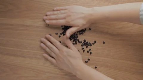Human hands pile up black beans on wooden table Video stock 112315757