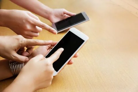Human hands pointing to screen of mobile phone,blurry light around. 写真素材