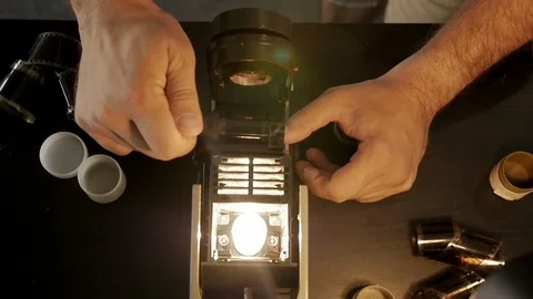 Human hands prepare the device for viewing and developing the film filmstrip Stock-Footage 111517365