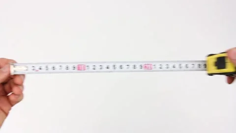 Human hands pull the measuring tape out of tape measure and measure width Video stock 135290795