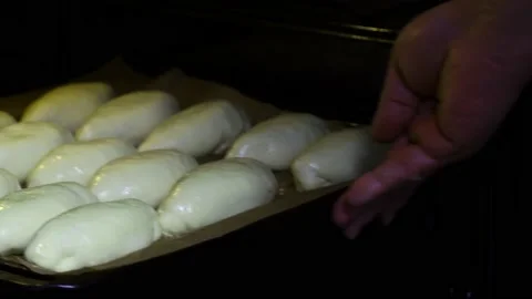 Human hands put the tray with the patties in the oven. Stock Footage 229757527