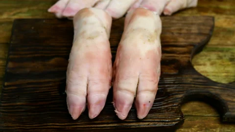 Human hands in rubber gloves funny banging with pork hooves. Stock Footage 129508757