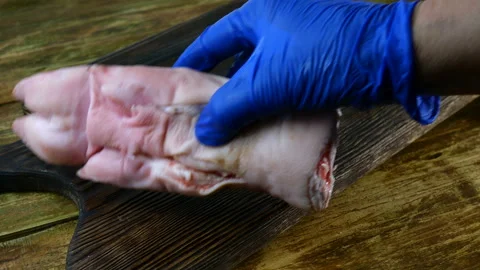 Human hands in rubber gloves neatly put raw pig legs. Stock Footage 129504873