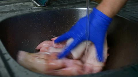 Human hands in rubber gloves thoroughly wash pig legs. Stock Footage 129504191