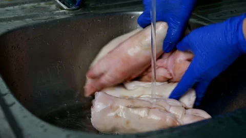 Human hands in rubber gloves thoroughly wash pig legs. Stock Footage 129931442