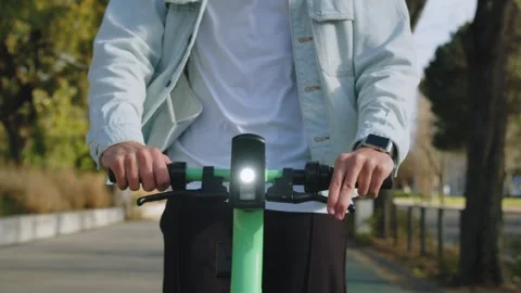 Human  hands on the steering wheel of electric scooter while riding in the .. Video stock 254660325