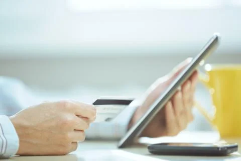 Human hands with tablet PC and credit card during lunch Stock Photos