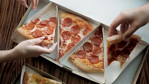 Human hands take slices of fresh pizza from an open box. Stock Footage 180073633