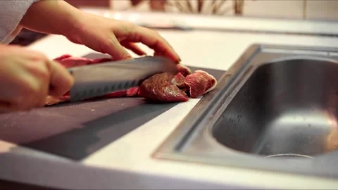 Human hands use a knife to cut meat. a man cuts up fresh meat for dinner in the  Vídeo Stock 144489035