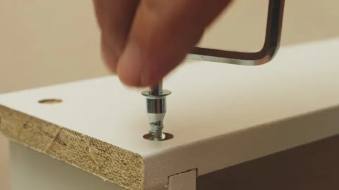 Human hands use a screwdriver to screw screws into furniture with drawers. .. 動画素材 333474208